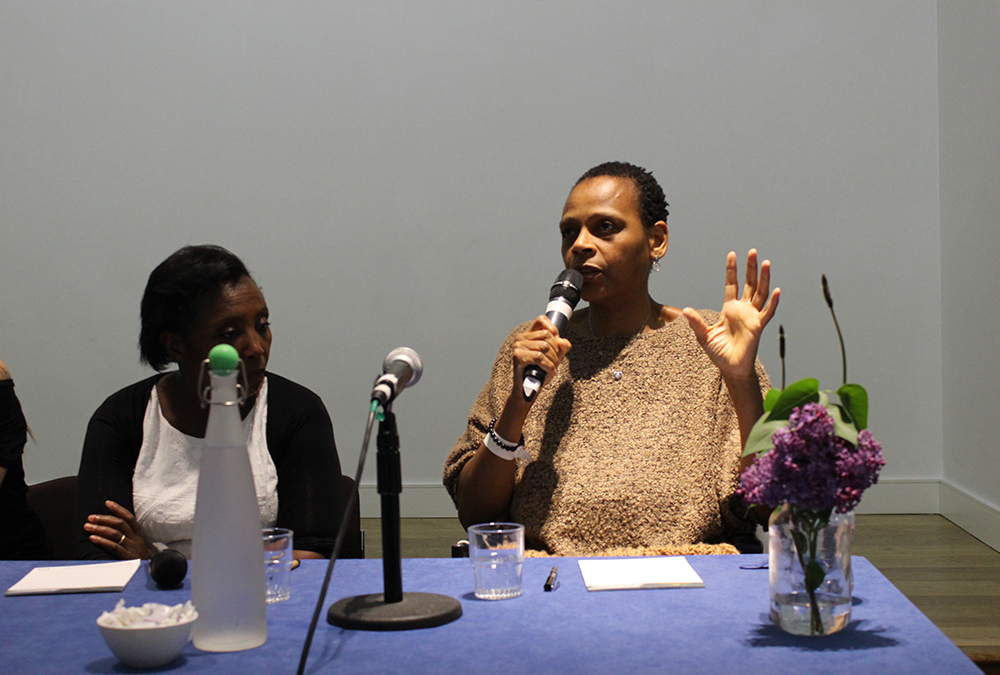 doreen-blake-sitting-along-pannel-with-microphone-at-dharma-inclusivity-event